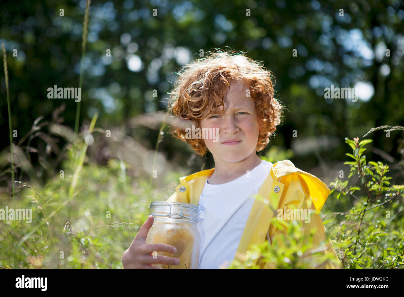 Mädchen mit Krug in Feld hohem Gras Stockfoto