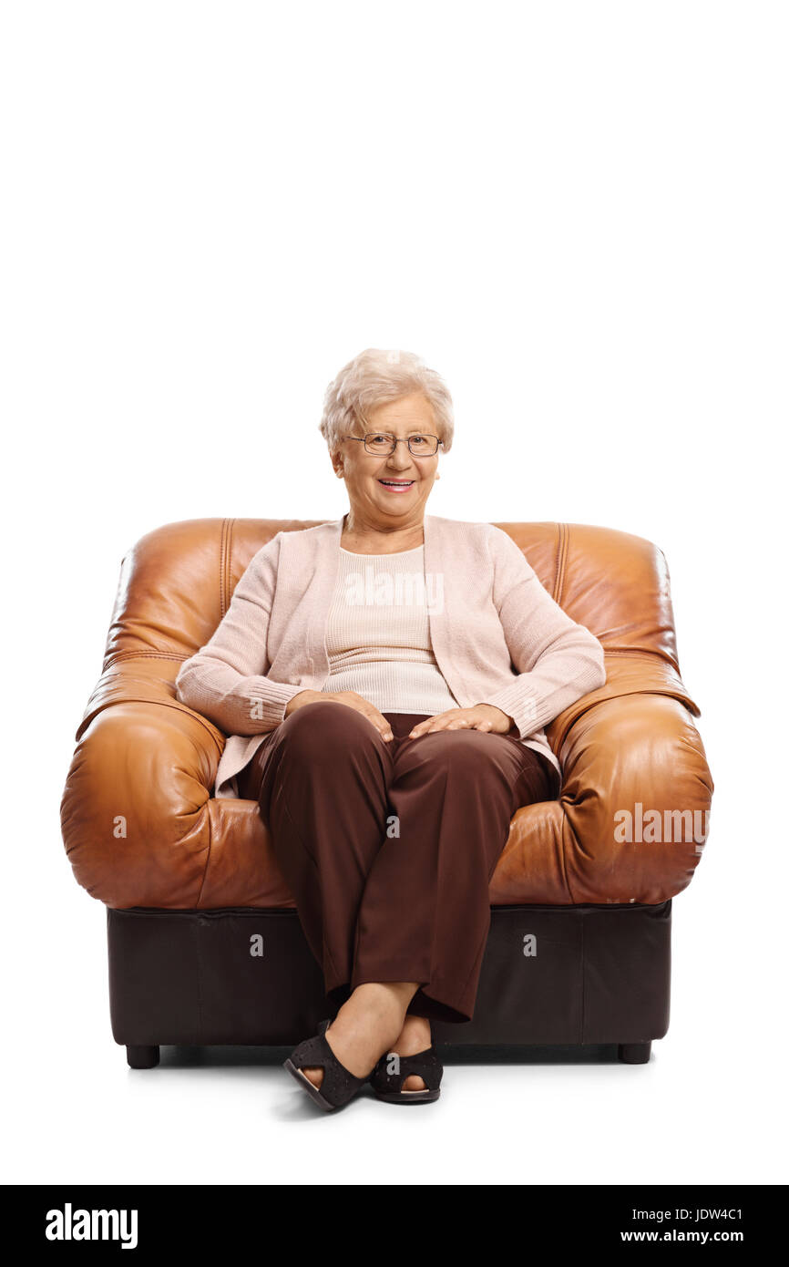 Reife Frau sitzt in einem Ledersessel und schaut in die Kamera, die isoliert auf weißem Hintergrund Stockfoto