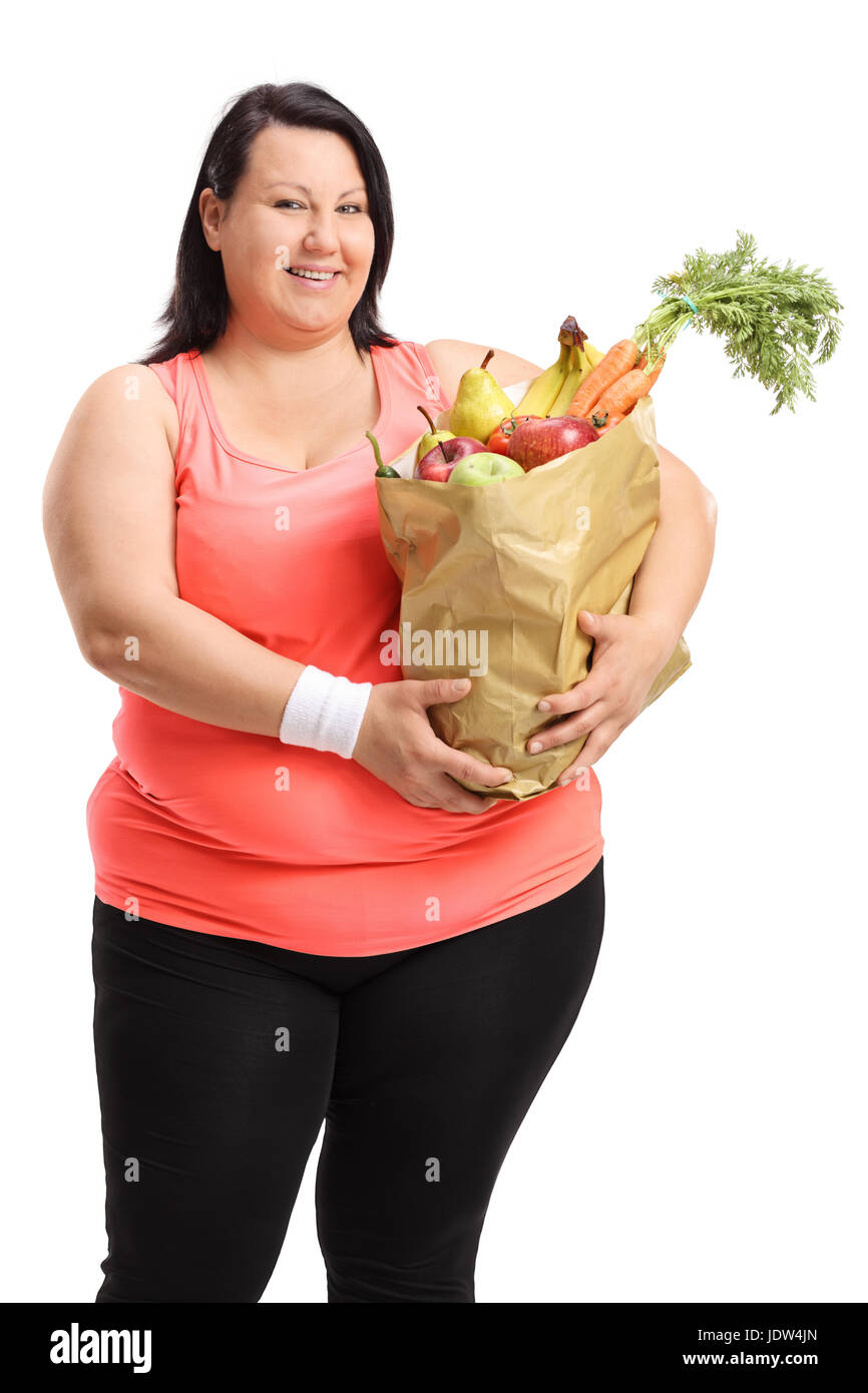 Übergewichtige Frau mit einer Papiertüte gefüllt mit Obst und Gemüse isoliert auf weißem Hintergrund Stockfoto