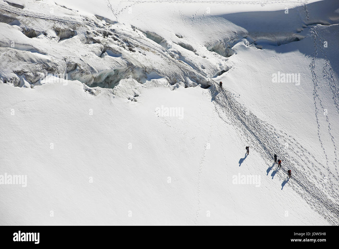 Bergsteiger durchqueren Tiefschnee, hoher Winkel Stockfoto
