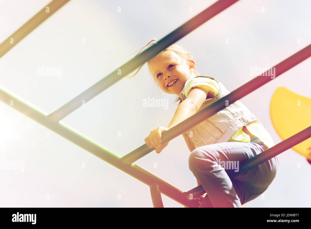glückliche kleine Mädchen Klettern am Kinderspielplatz Stockfoto