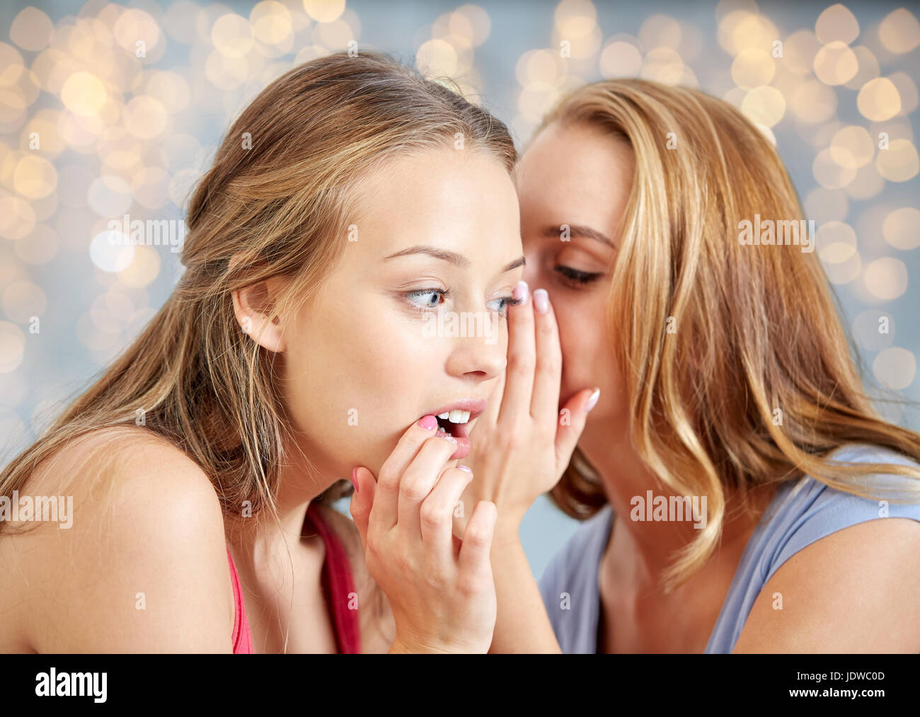 glückliche junge Frauen Flüstern Klatsch Stockfoto
