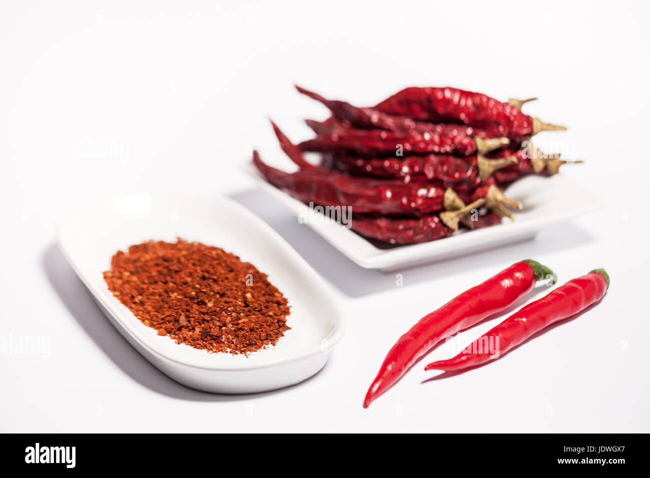 Rote Chilis in 3 verschiedenen Formen, frische rote Chilis, Chilipulver und getrocknete Chilischoten auf weißem Hintergrund mit Textfreiraum. Schöne Food-Fotografie Stockfoto