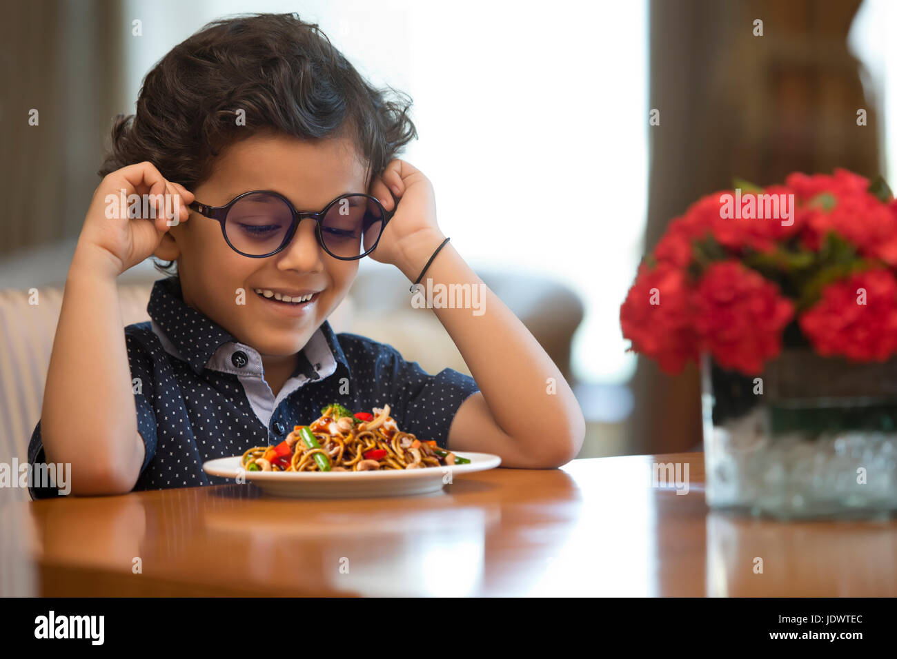 Nahaufnahme eines lächelnden jungen mit Nudeln Platte auf Tisch Stockfoto