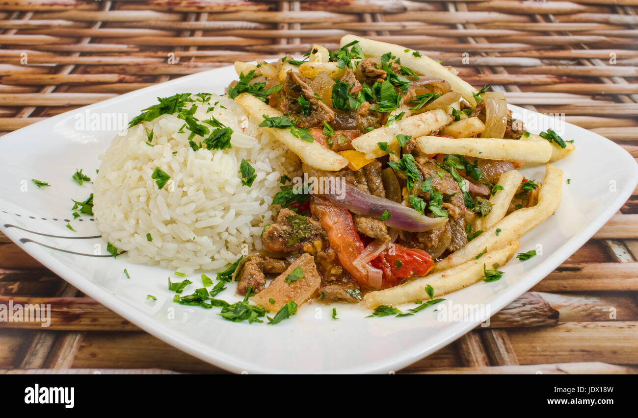 Lomo Saltado ein peruanisches Gericht mit sautiertem Rindfleisch, Tomaten, Zwiebeln, Bratkartoffeln und Reis. Stockfoto