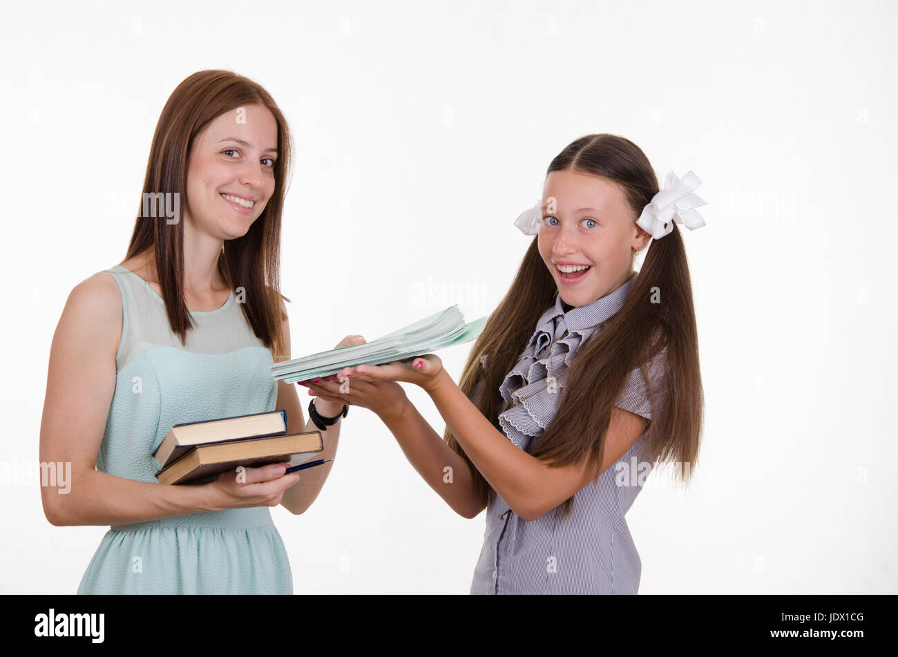 Schullehrer gibt dem Studenten einen Stapel von Notizbüchern Stockfoto