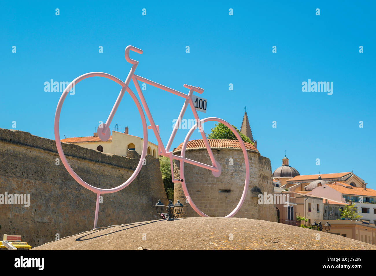 Rosa Fahrrad, ein Modell in einem rosa Rennrad auf einem kleinen Turm im Hafengebiet von Alghero im Norden Sardiniens gelegen. Stockfoto