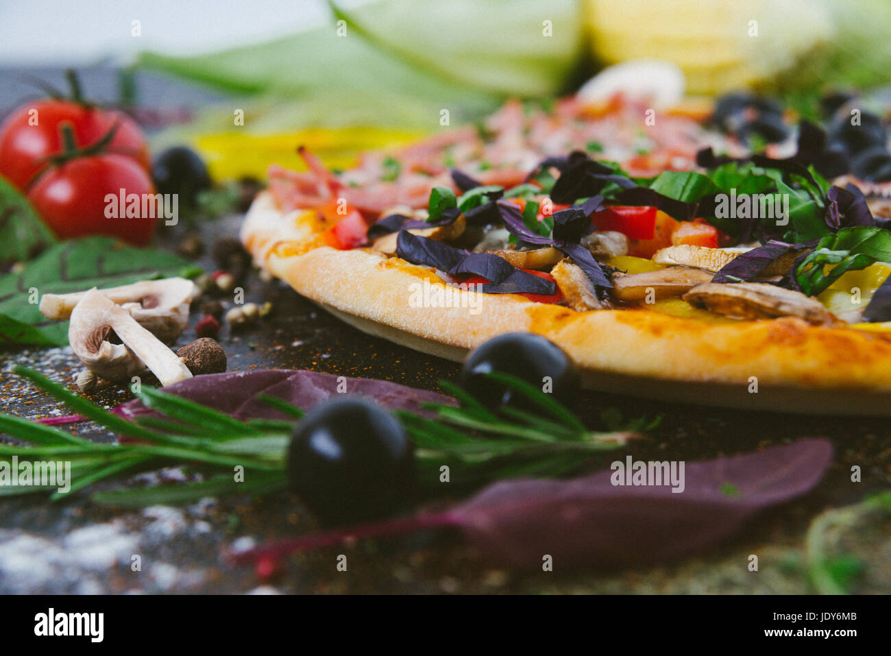 Italienische Pizza mit Mozzarella, schwarzen Oliven, Schinken und ...