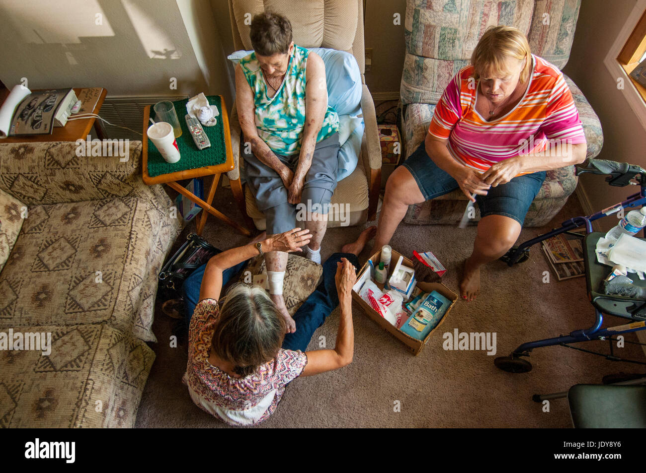 Zwei 50-55 Jahre alten kaukasischen Schwestern helfen ihre 84 Jahre alte Mutter mit Bandagen, von oben fotografiert. Stockfoto