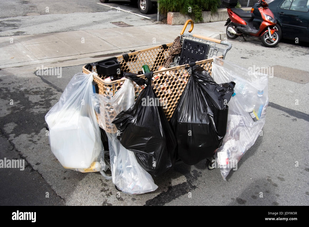 Obdachloser shopping Wagen beladen mit mehreren Kunststoff Besitz Taschen. Horizontale. Stockfoto