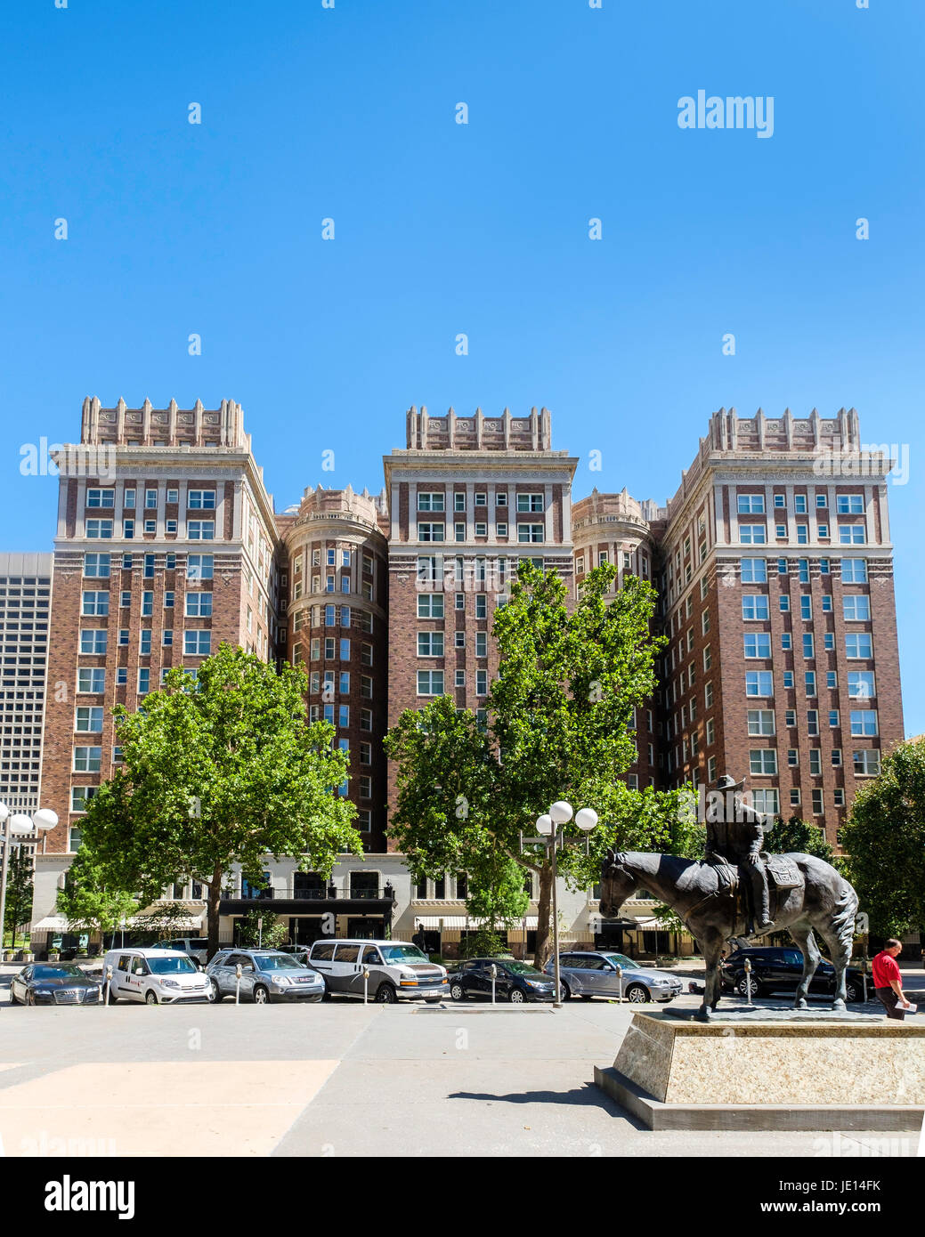 Historisches Skirvin Hilton-Hotel in der Innenstadt von Oklahoma City, OK, USA, gebaut 1910 komplett mit einem Geist. Cotter Ranch-Turm-Skulptur im Vordergrund. Stockfoto