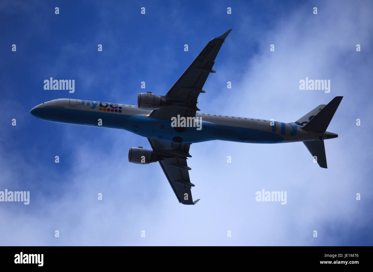 Blaue und weiße Passagierflugzeug fliegen links in geringer Höhe Stockfoto
