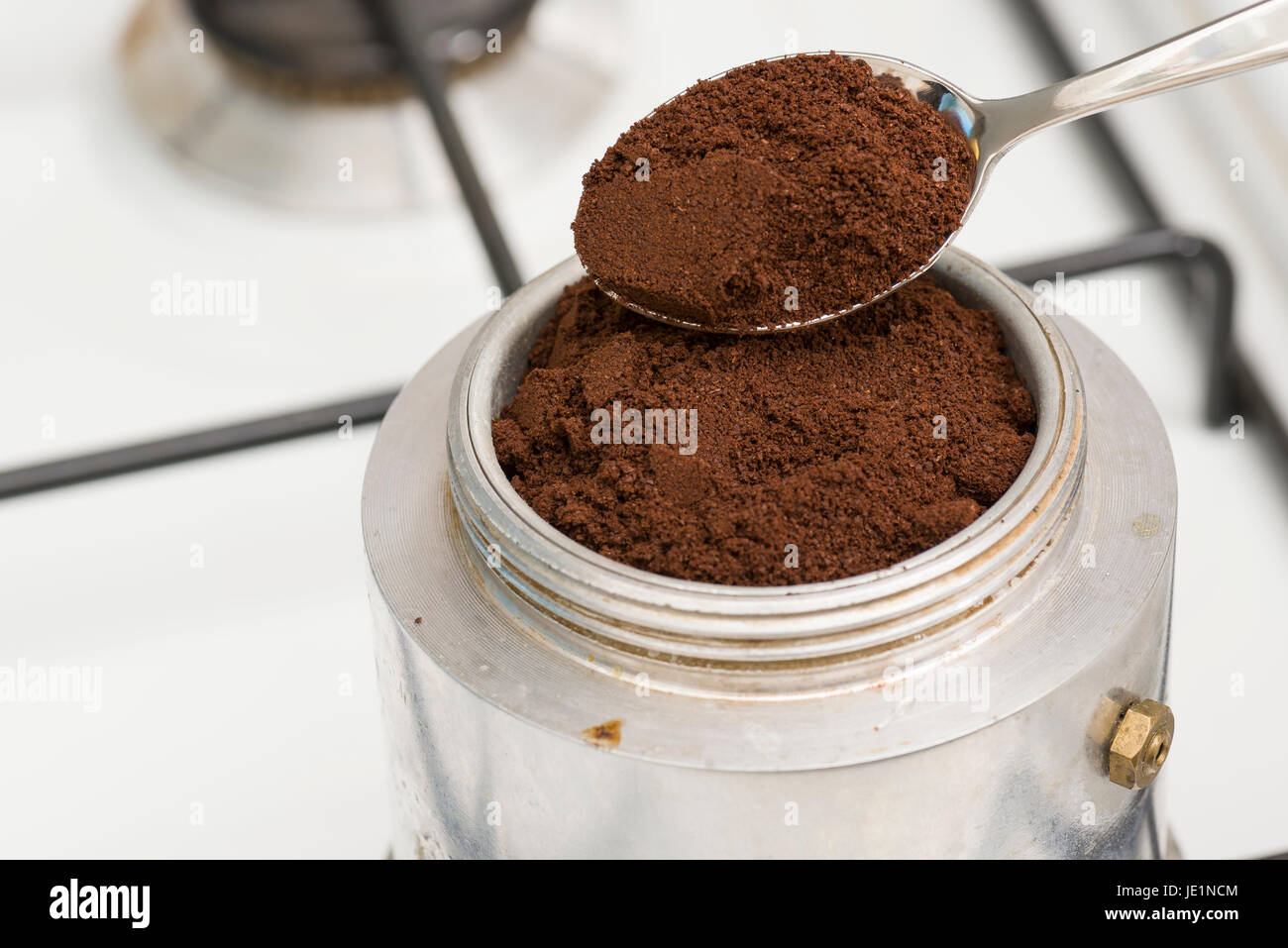Füllen Sie den Mokka mit einem Teelöffel Kaffee zu machen. Stockfoto