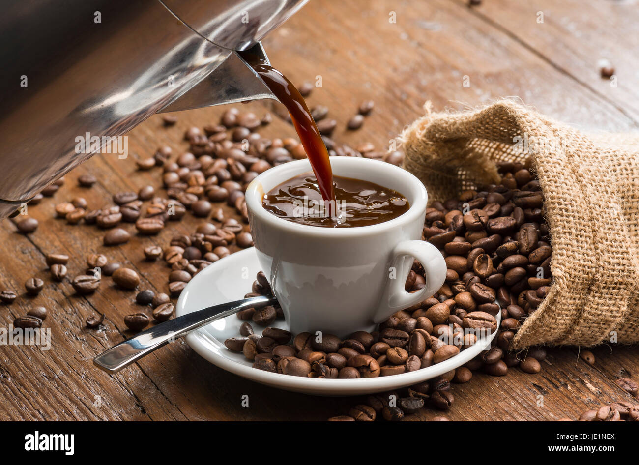 Milchkaffee Tasse Kaffee aus der Kaffeemaschine überfluten. Stockfoto