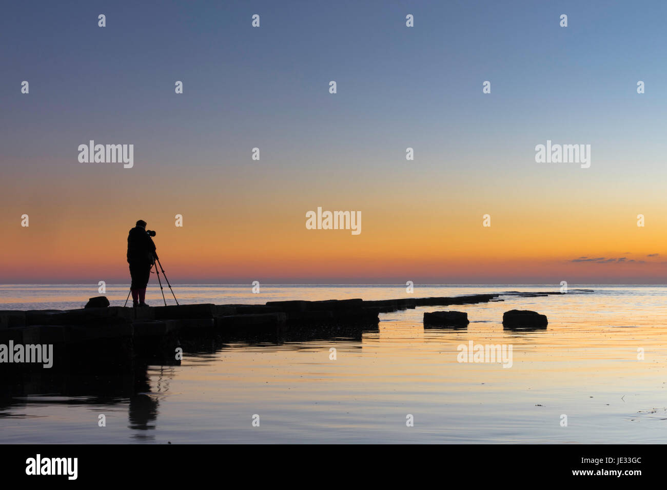 Fotograf bei kimmeridge Bay, dorset während der Goldenen Stunde Stockfoto