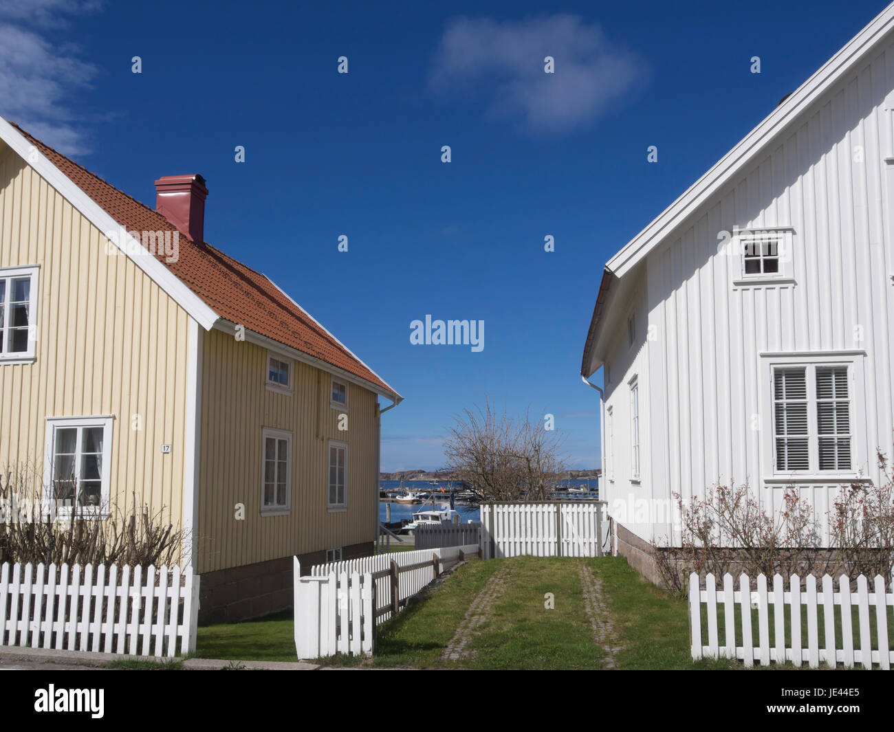 Die kleine Stadt Fjallbacka an der Westküste von Schweden, ein Urlaubsziel, Blick auf das Meer zwischen den malerischen Häusern und Lattenzäune Stockfoto