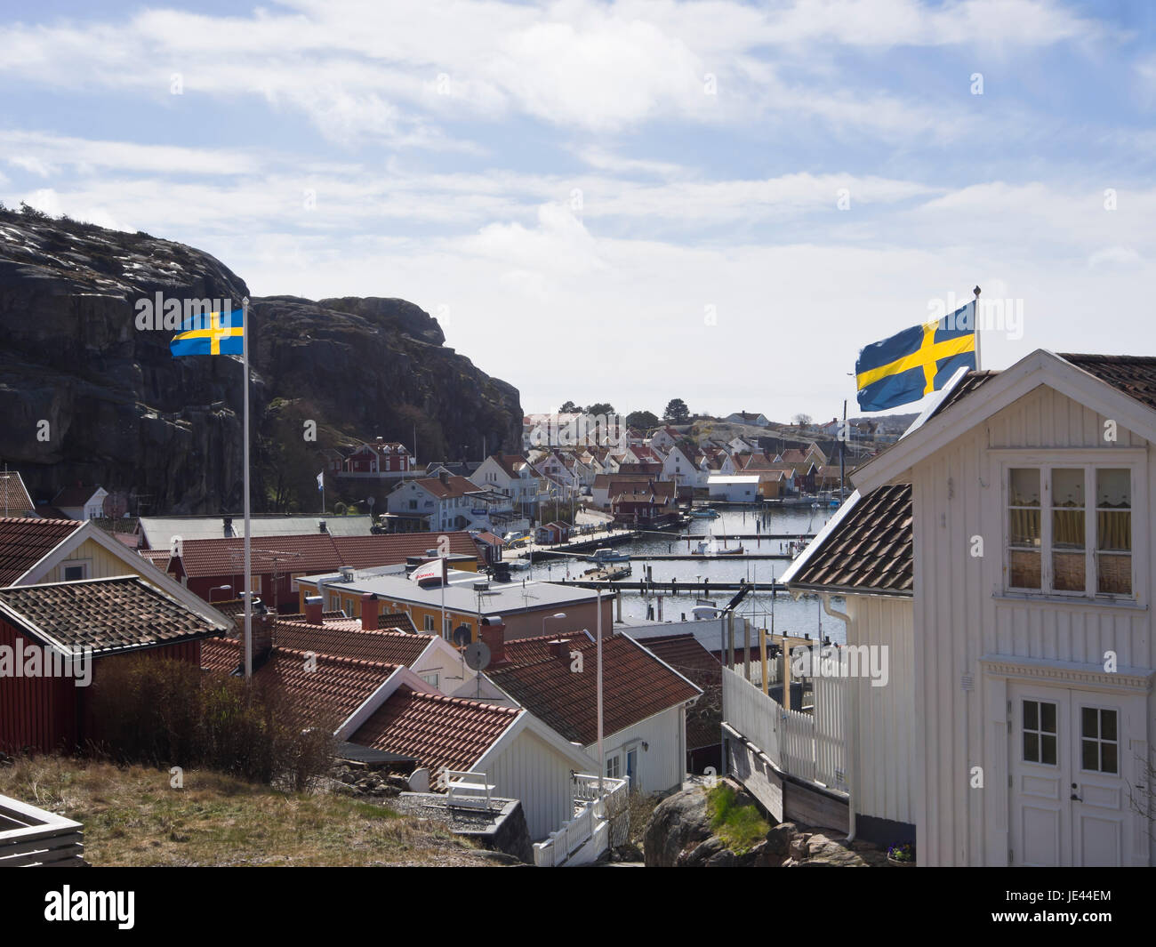 Die kleine Stadt Fjallbacka an der Westküste von Schweden, ein Urlaubsziel, Blick auf Hafen und Marina, schwedischen Fähnchen über den Dächern Stockfoto