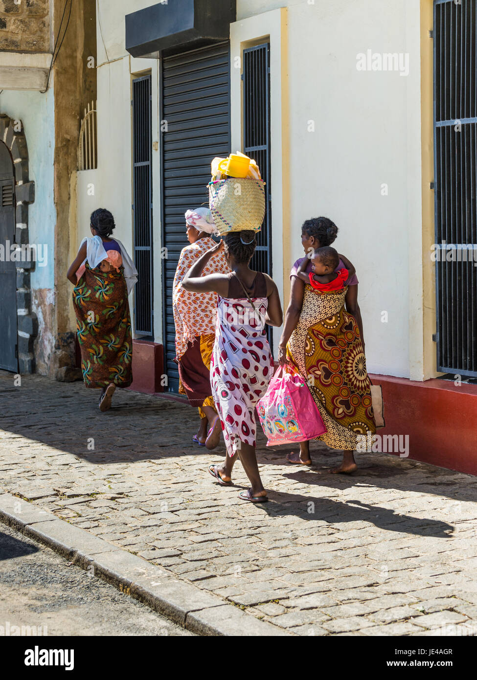 Antsiranana, Madagaskar - 20. Dezember 2015: Unidentified madagassische Frauen gehen und in Antsiranana (Diego Taschen auf dem Kopf und ein Baby auf dem Rücken tragen Stockfoto