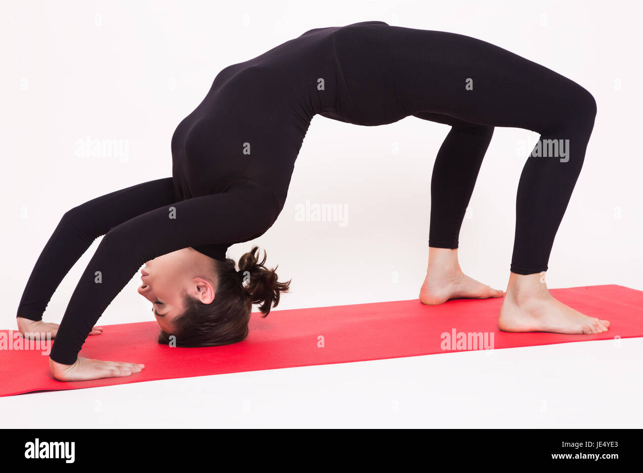 Schöne sportliche Mädchen im schwarzen Anzug, die Yoga-Asanas zu tun. Isoliert auf weißem Hintergrund. Stockfoto
