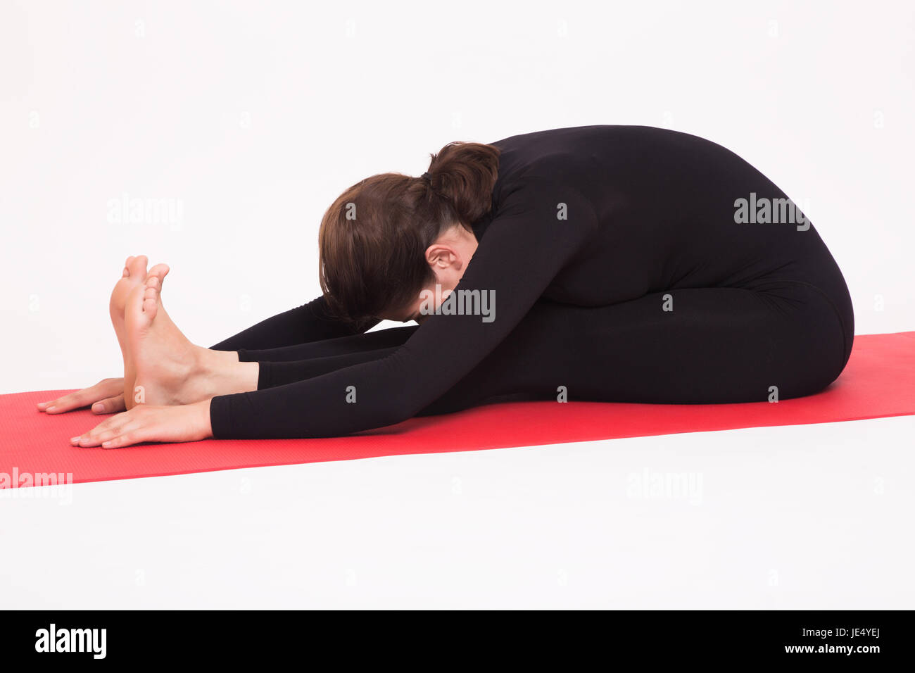 Schöne sportliche Mädchen im schwarzen Anzug, die Yoga-Asanas zu tun. Isoliert auf weißem Hintergrund. Stockfoto