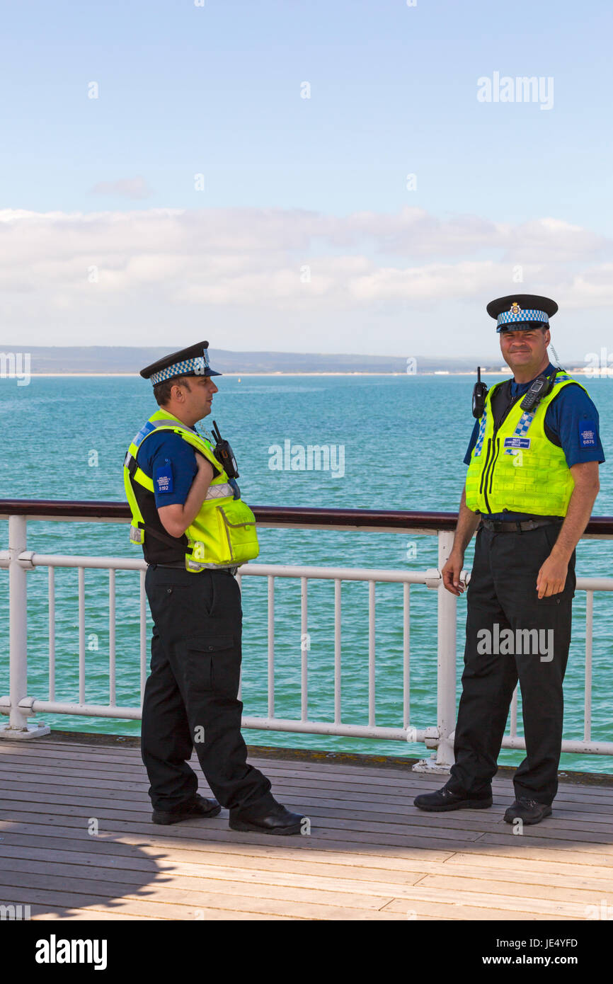 Police Community Support Officers stehen auf Bournemouth Pier in Bournemouth, Dorset im Juni Stockfoto
