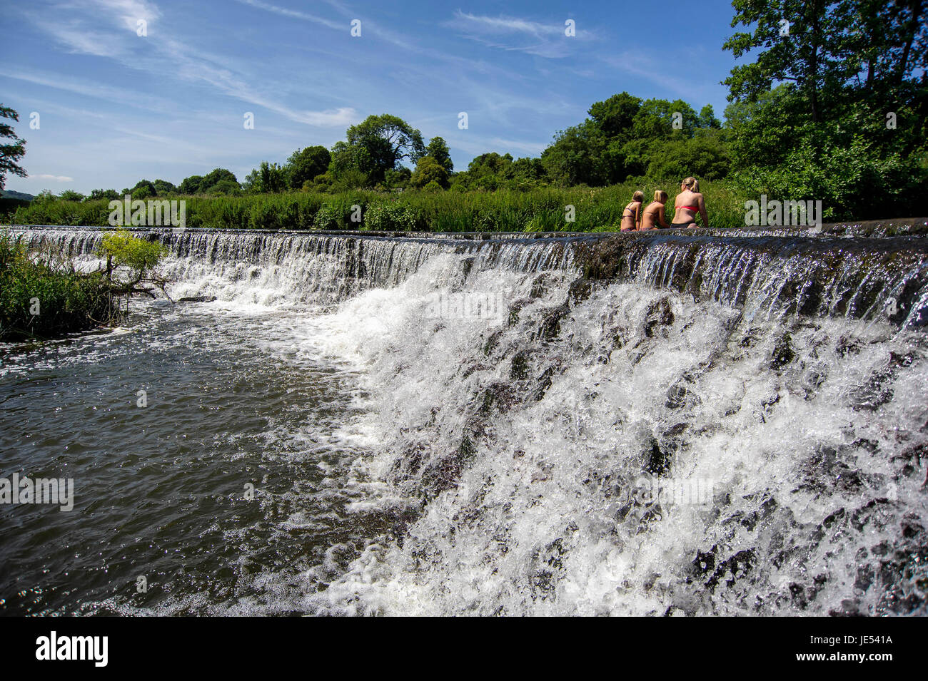 Schwimmer und Sonnenanbeter genießen das Wasser beim Warleigh Wehr am Fluss Avon in der Nähe von Bath in Somerset. Stockfoto