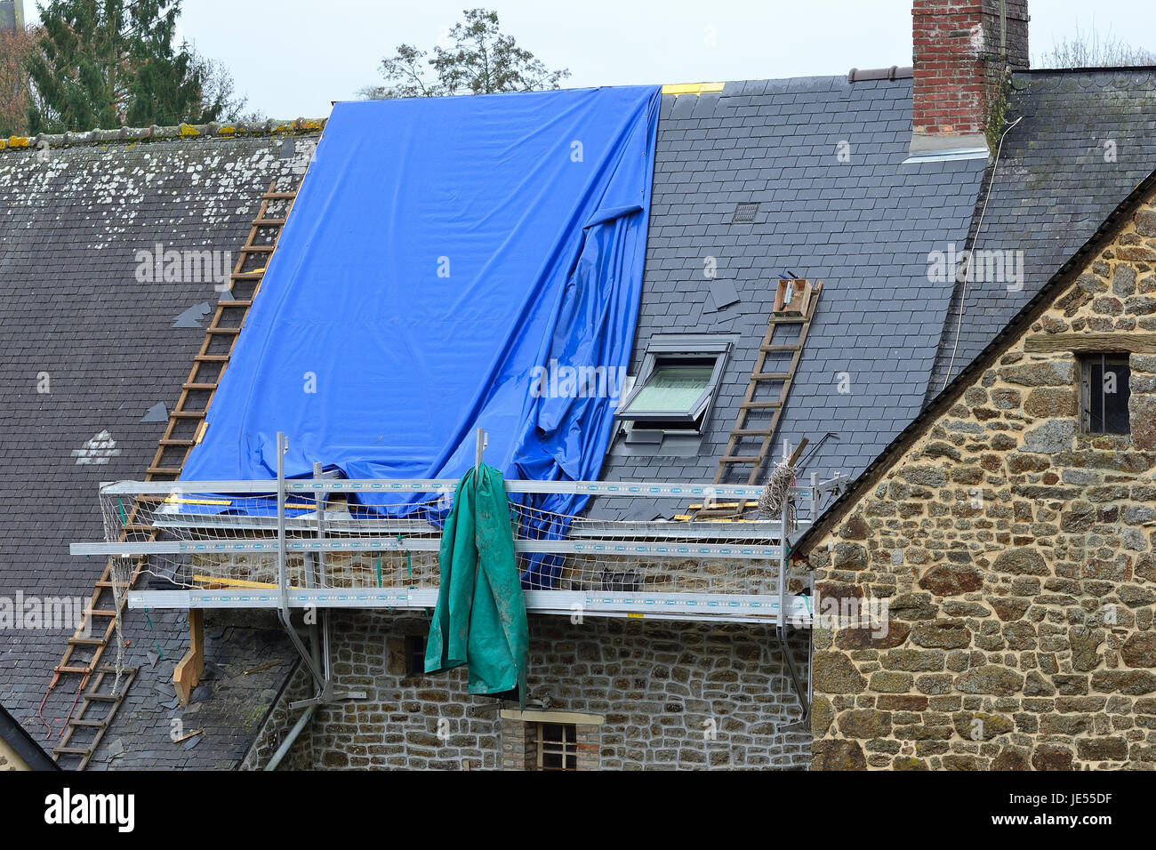 Reparatur eines Daches eines alten Hauses in einem französischen Dorf (Mayenne, Land der Loire, Frankreich). Stockfoto