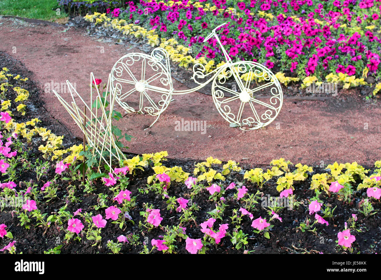 Dekorative Fahrrad auf einem Blumenbeet Stockfoto