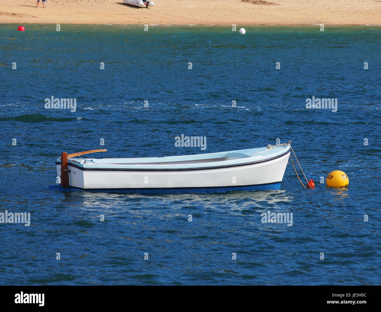 Weiß und blau Angelboot/Fischerboot auf gelbem Liegeplatz in Salcombe, Devon. Stockfoto