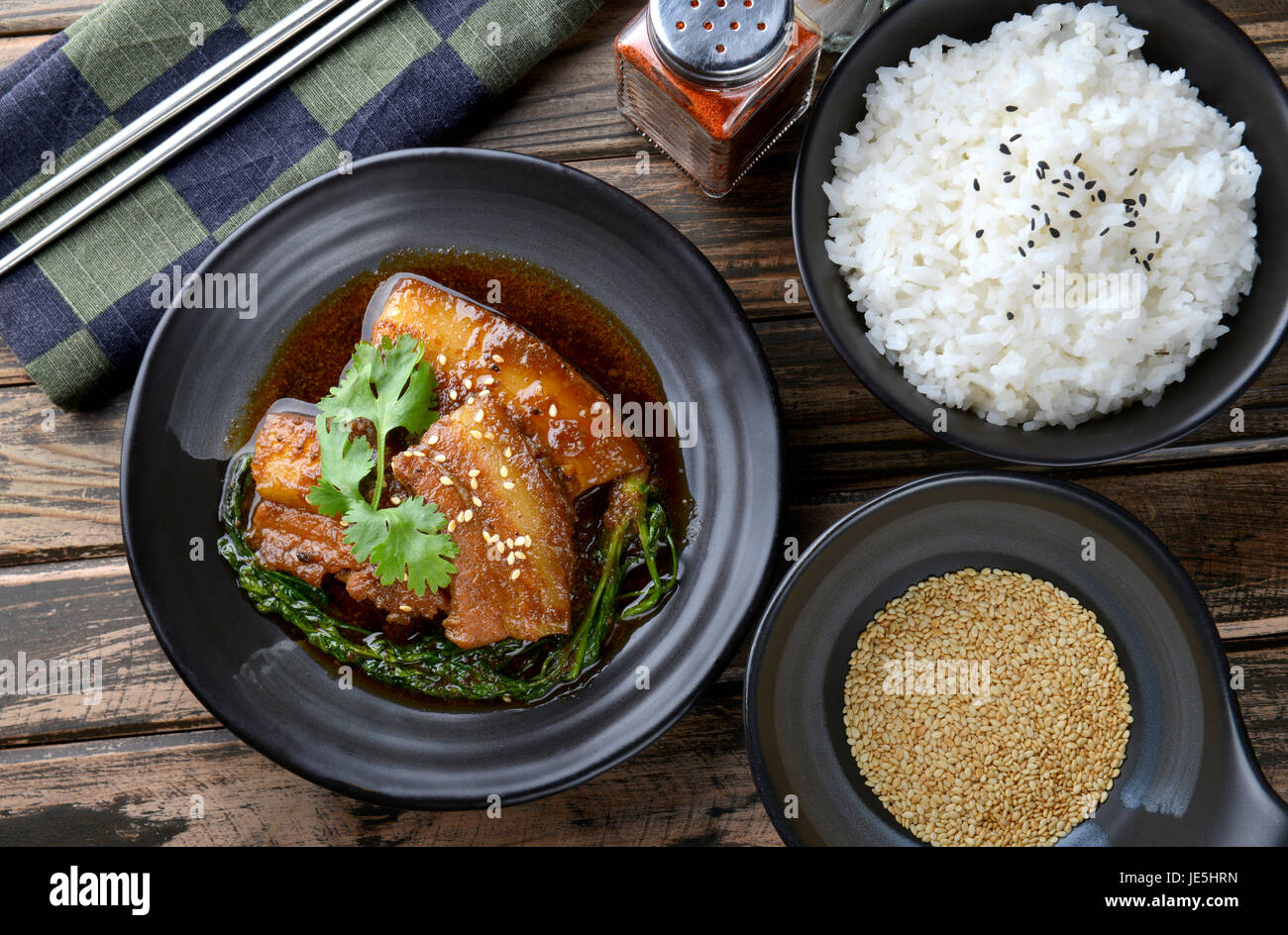 Chinesische süß gedünstet Schwein Einstellung auf schwarzen japanischen Stil Teller in Studiobeleuchtung. Stockfoto