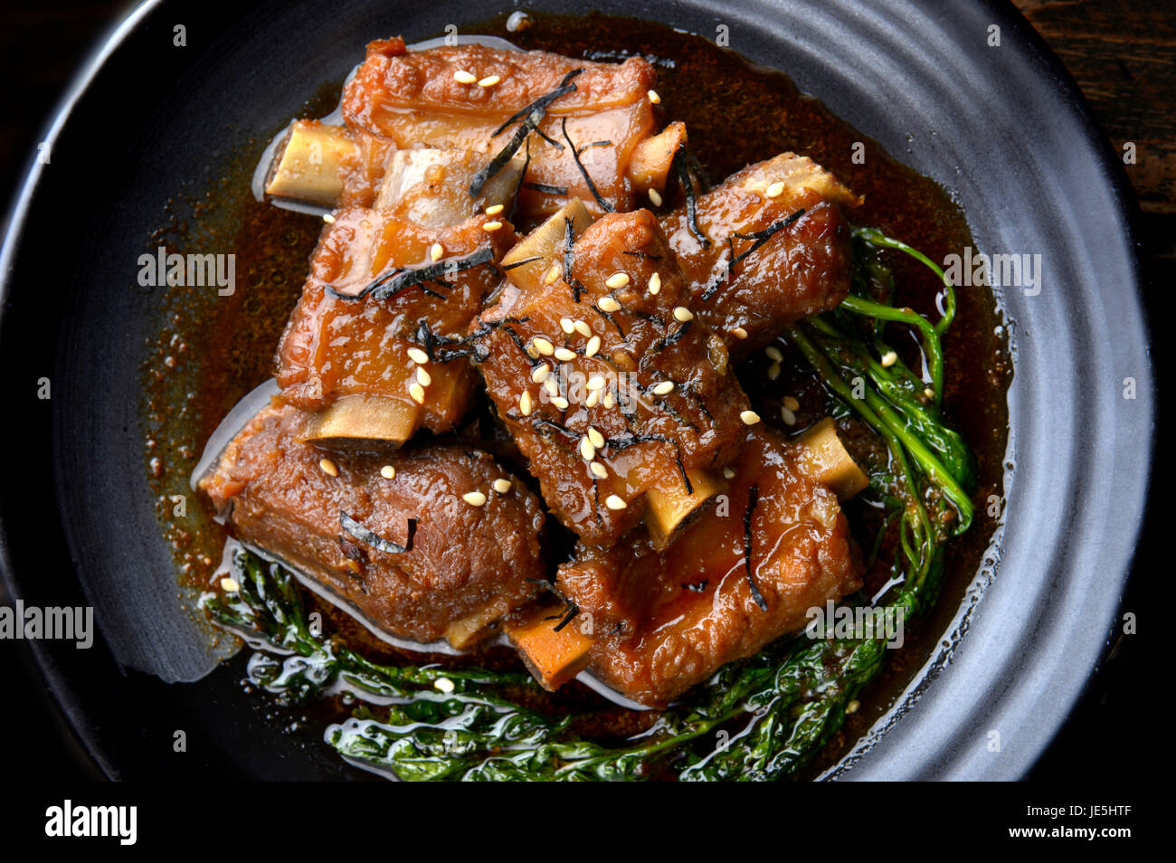 Chinesische süß gedünstet Schwein Einstellung auf schwarzen japanischen Stil Teller in Studiobeleuchtung. Stockfoto