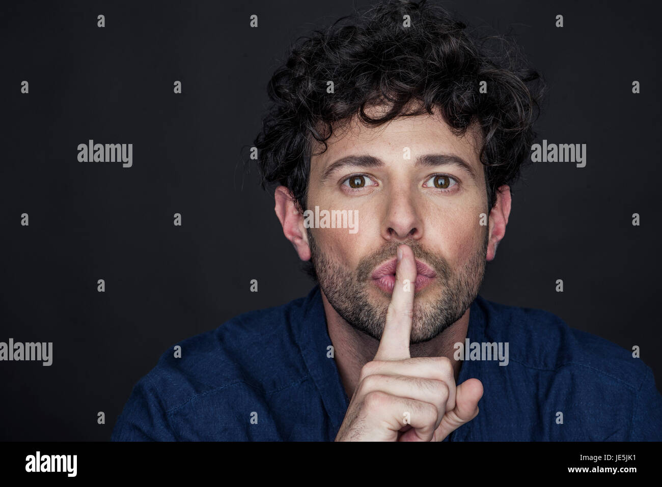 Mann mit Finger an die Lippen gehalten-Stummschaltung Stockfoto