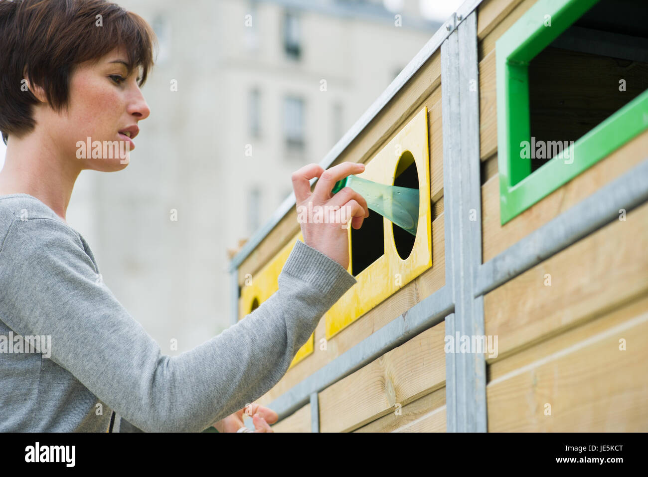 Frau Plastikflasche in Recyclingbehälter platzieren Stockfoto