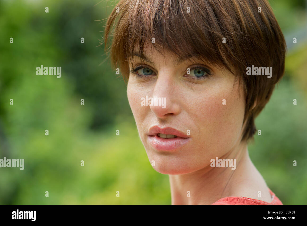 Frau auf der Suche über die Schulter, Porträt Stockfoto