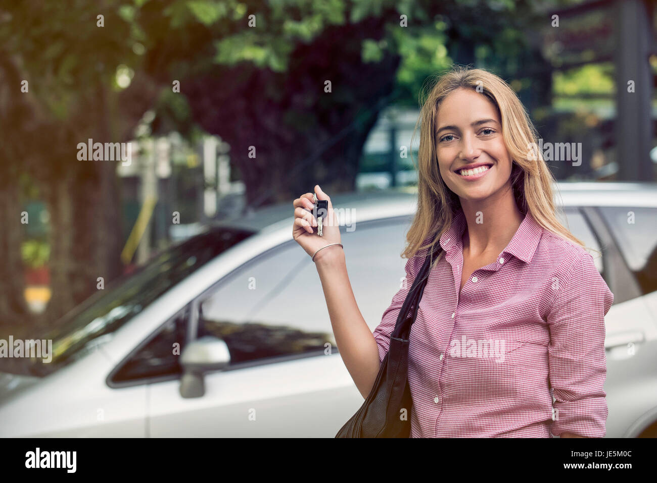 Junge Frau mit Autoschlüssel, lächelnd, fröhlich, Porträt Stockfoto