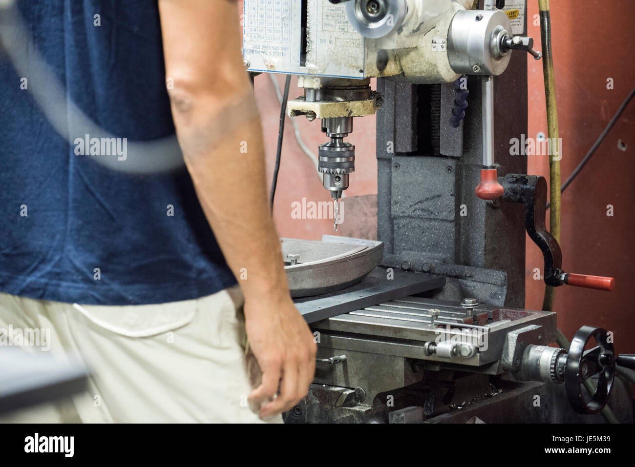 Fabrikarbeiter, die mit Bohrer Stockfoto