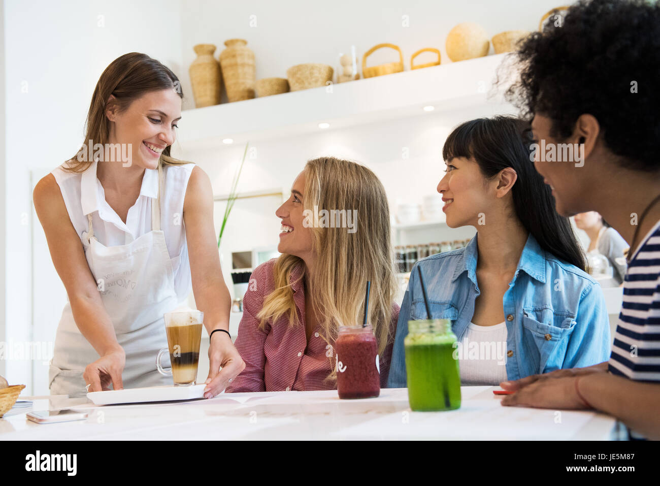 Kellnerin serviert Drinks für Frauen im café Stockfoto