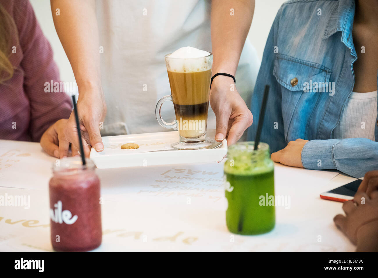 Kellnerin serviert Getränke im Café, beschnitten Stockfoto