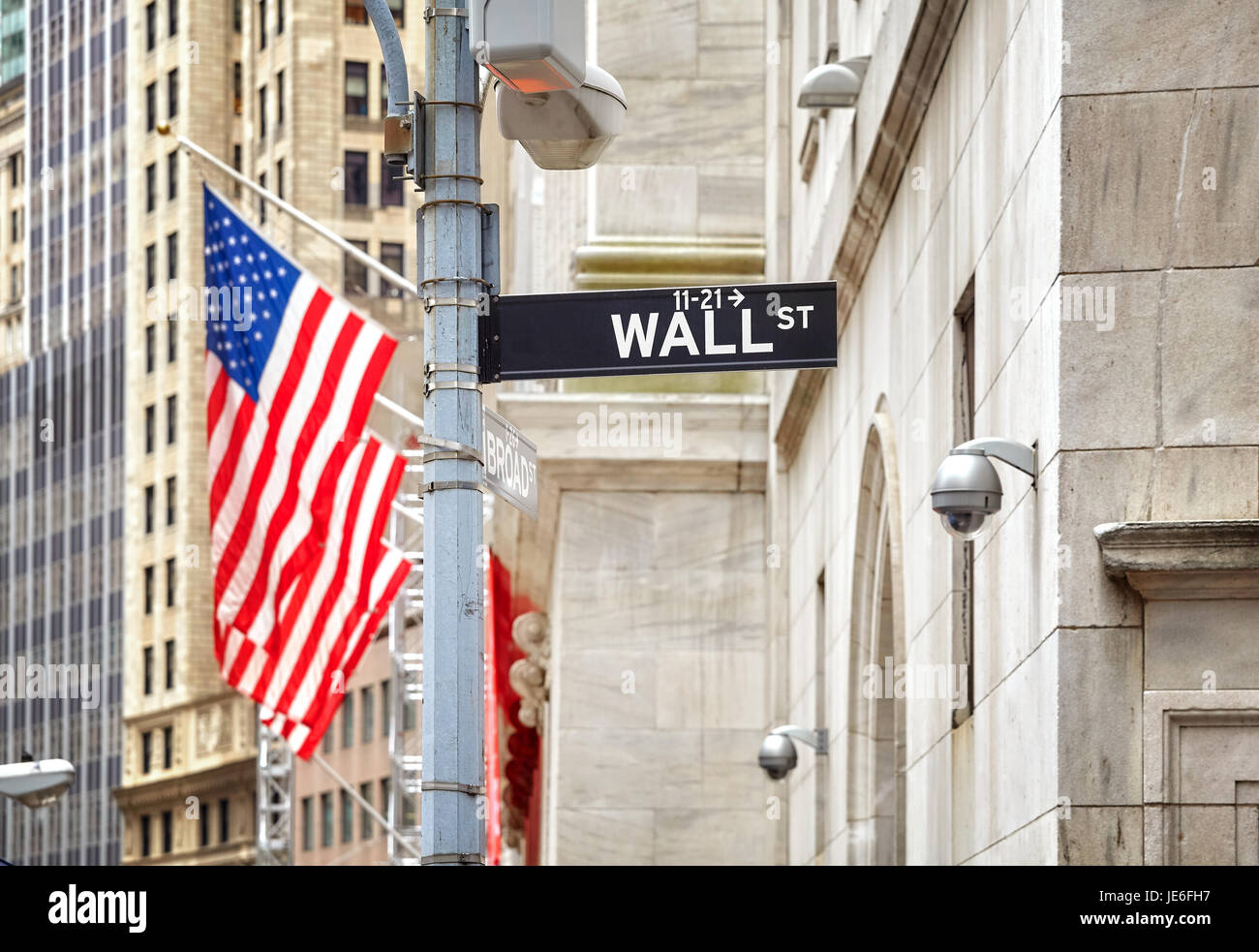 Wall Street Schild mit amerikanischer Flagge in Ferne, geringe Schärfentiefe, New York City, USA. Stockfoto