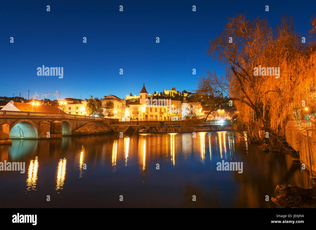 Die historische Stätte von Tomar in der Abenddämmerung. Die Brücke römischen Ursprungs und auf dem Hügel das Schloss des Klosters Templer Christi. Tomar, Portugal Stockfoto