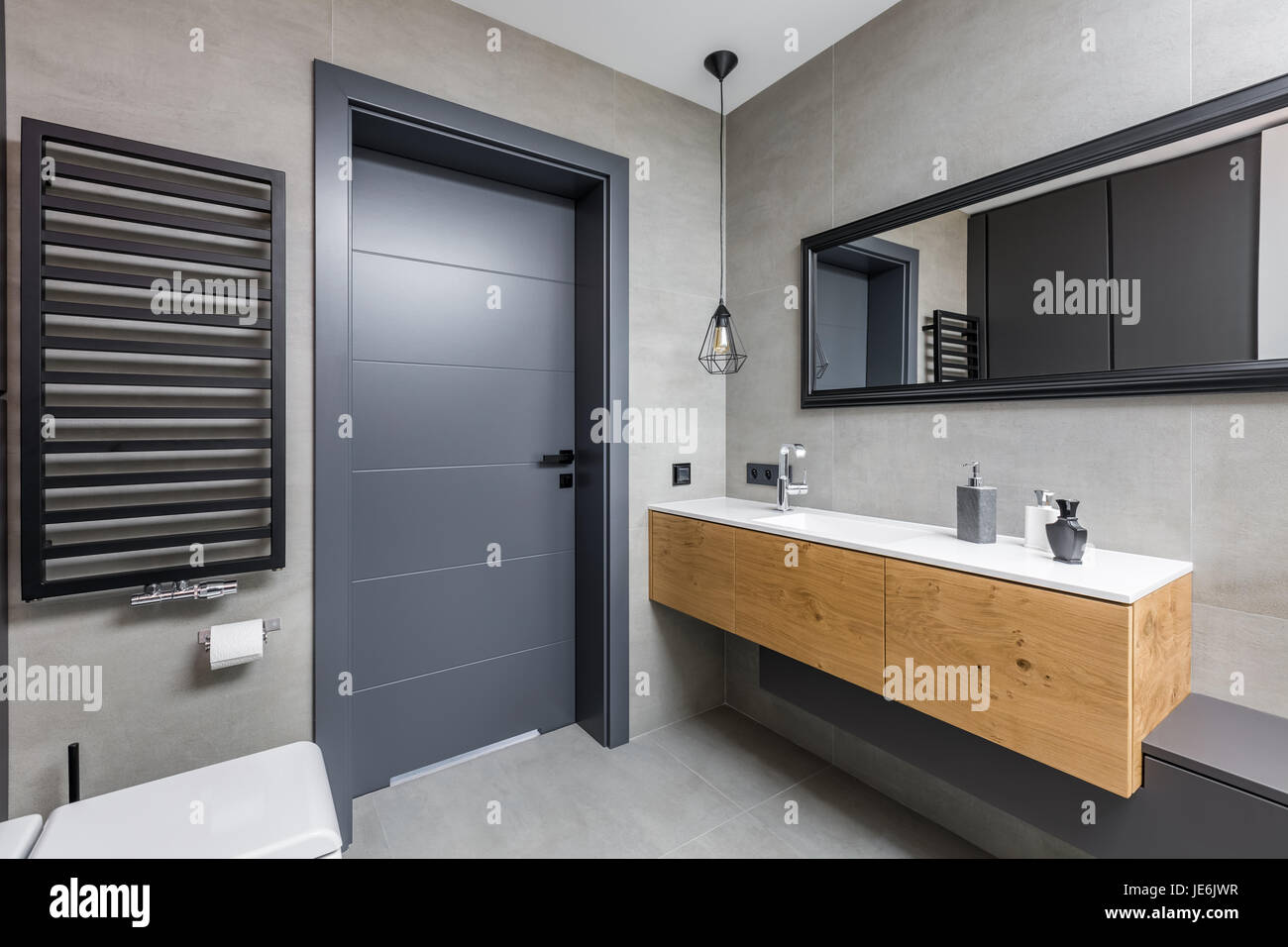 Dunkle und elegante Badezimmer mit Arbeitsplatte Waschbecken und Spiegel Stockfoto