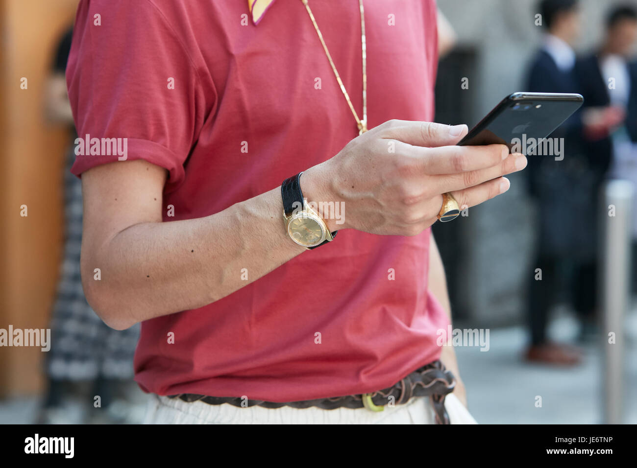 Mailand - 17.Juni: Mann mit goldenen Rolex-Uhr Check-Smartphone vor Emporio Armani-Modenschau, Milan Fashion Week Streetstyle am 17. Juni 2017 Stockfoto