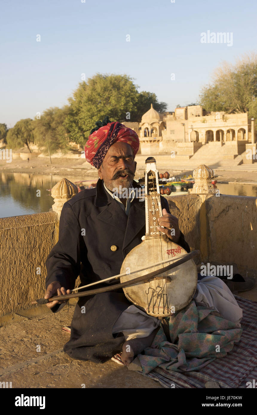 Indien, Rajasthan, Jaisalmer, Gadi Sagar See, Alter Mann spielt auf Saiteninstrument, Stockfoto