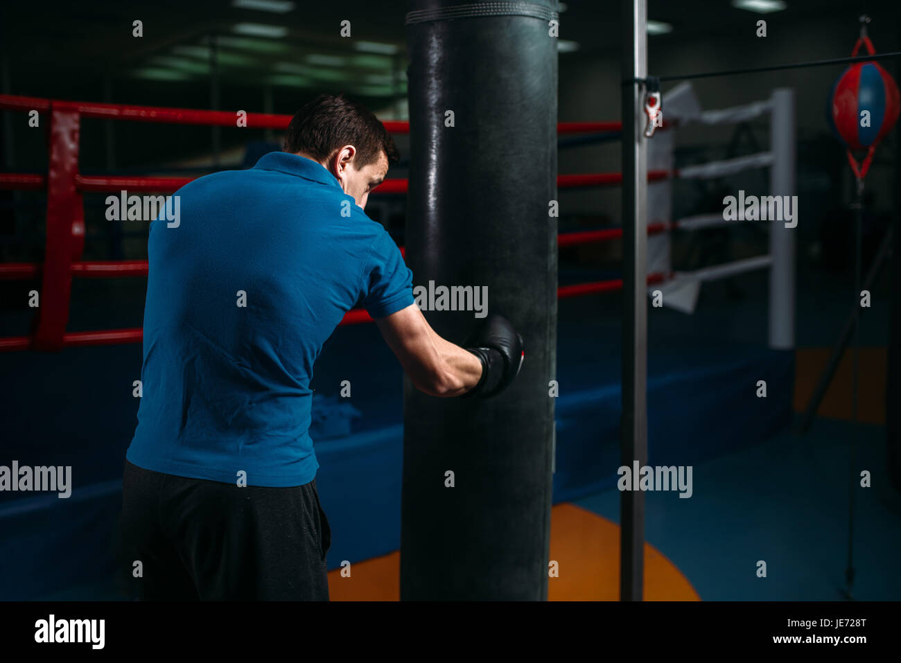 Mann in schwarz Boxbandagen Übungen mit Tasche im Fitness-Studio. Boxtraining, Herren sport Stockfoto