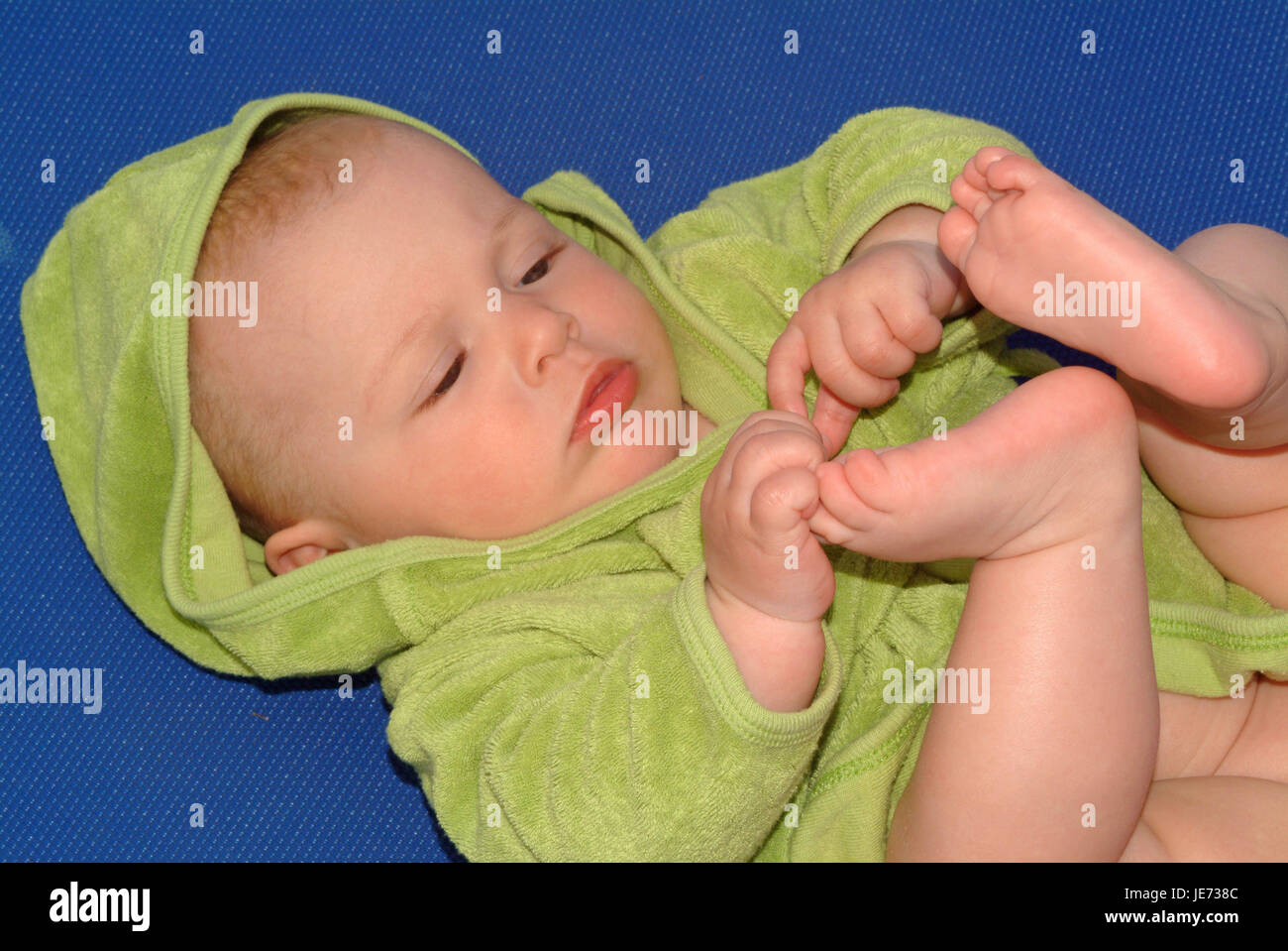6 Monate altes Baby spielt mit seinen Füßen, Stockfoto