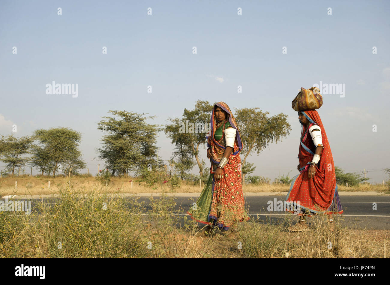 Indien, Gujarat, zwei Frauen in traditioneller Tracht auf der Landstraße, Stockfoto