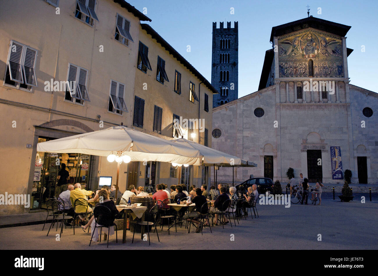 Italien, Toskana, Lucca, Touristen sitzen auf dem Platz vor der Kirche San Frediano in der Nacht, Stockfoto