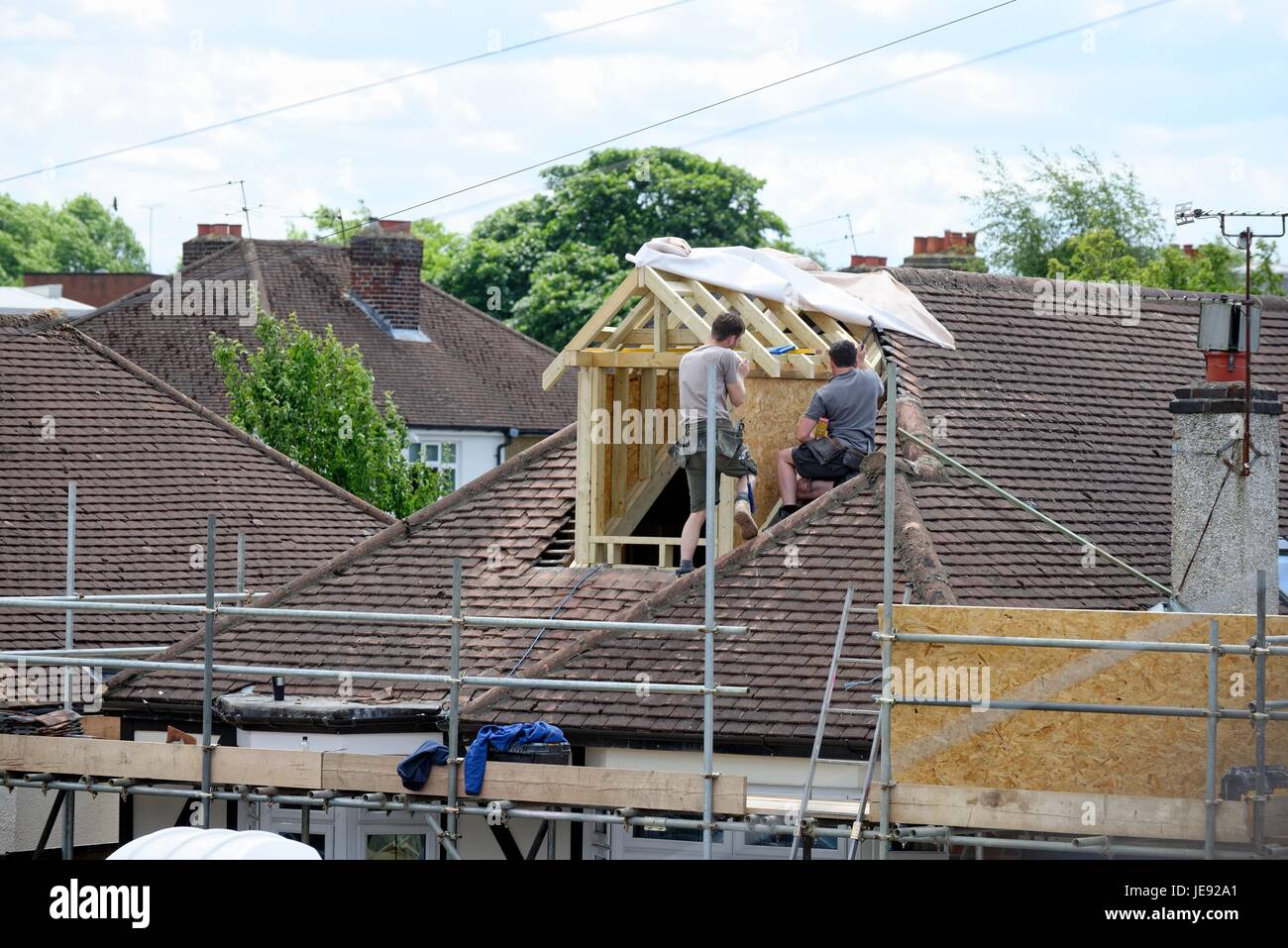 Bauherren Bau eine Loft-Erweiterung auf einem suburban Bungalow England UK Stockfoto