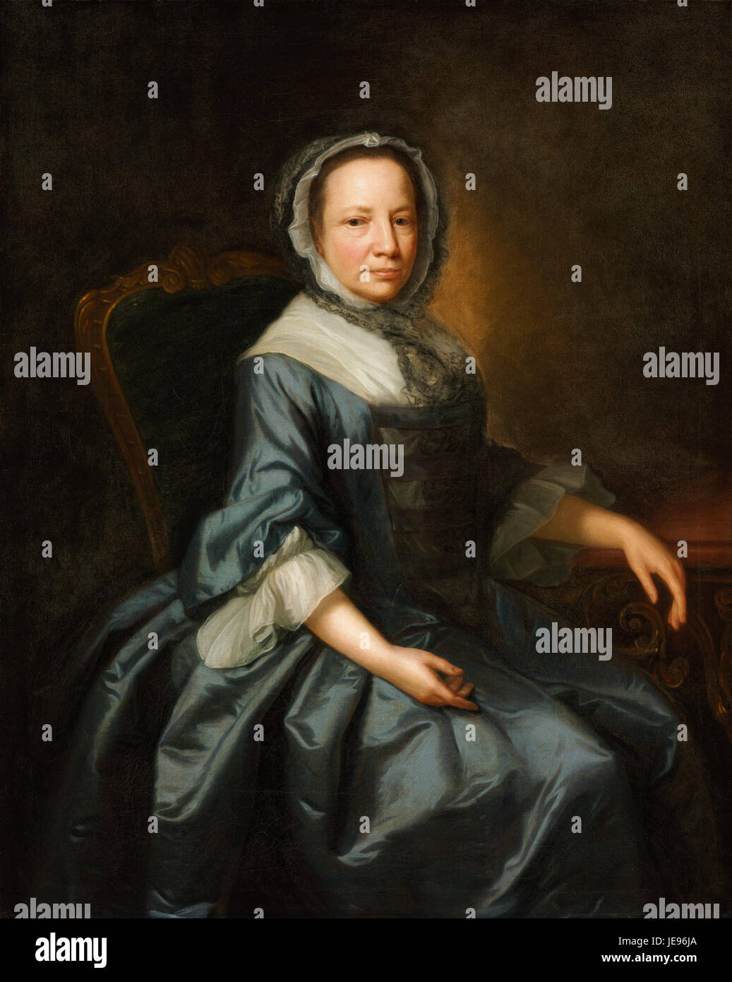 Das Porträt einer Dame, das Thomas Hudson zugeschrieben wird, zeigt eine Figur in einer detaillierten, eleganten Pose. Das Gemälde betont die raffinierte Kleidung und die königliche Präsenz des Motivs, wobei das Gesicht und die Kleidung durch sanfte Beleuchtung hervorgehoben werden. Das Werk spiegelt Porträtstile des 18. Jahrhunderts wider, wobei der Schwerpunkt auf Realismus und der Verwendung von Licht und Schatten liegt. Stockfoto
