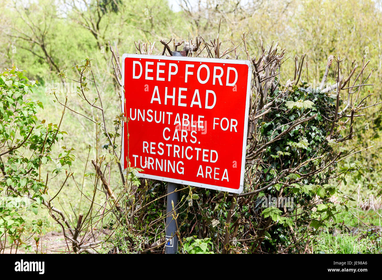 Eine rote Warnung Schild mit der Aufschrift "Tiefe Ford voraus ungeeignet für Autos eingeschränkt drehen Gegend" Stockfoto